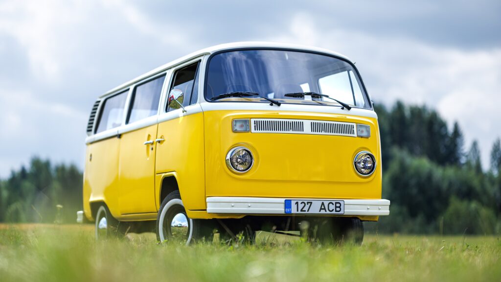 Yellow Volkswagen Bus parked in grass field